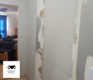 A wall with drywall installed and prepared for patching and mudding by Waterbury Drywall in Waterbury, CT.