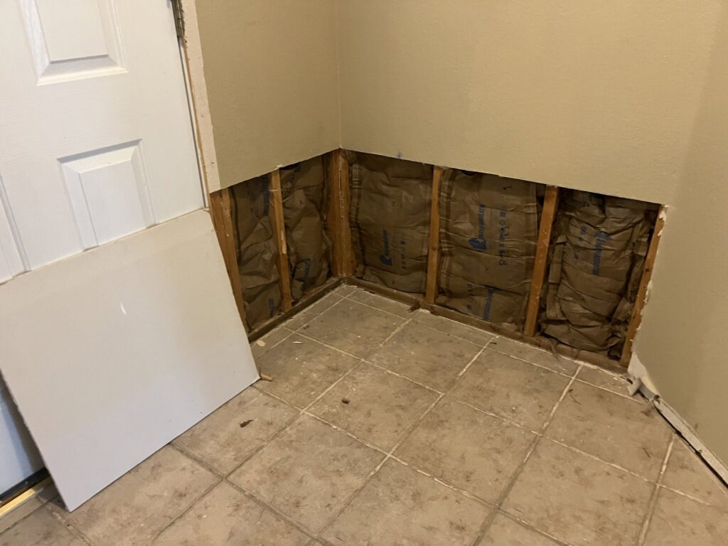 Drywall removed exposing insulation and studs for repair by San Marcos Drywall and Paint in Austin, TX