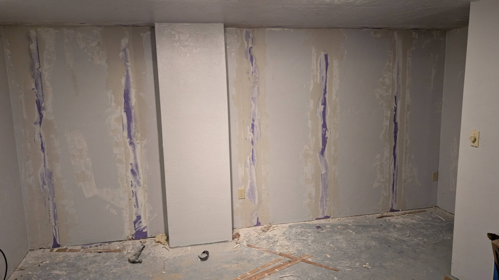 A wall showing drywall repair and patching work in progress by GCB Home Improvement in Appleton, WI.
