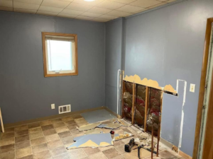 Room undergoing renovation with drywall removed, showing handyman repair work by SMB Construction in Toledo, OH.