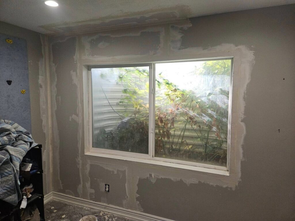 Drywall repair and patching around a window, a service provided by Honeycomb Handyman Services in Salt Lake City, UT.