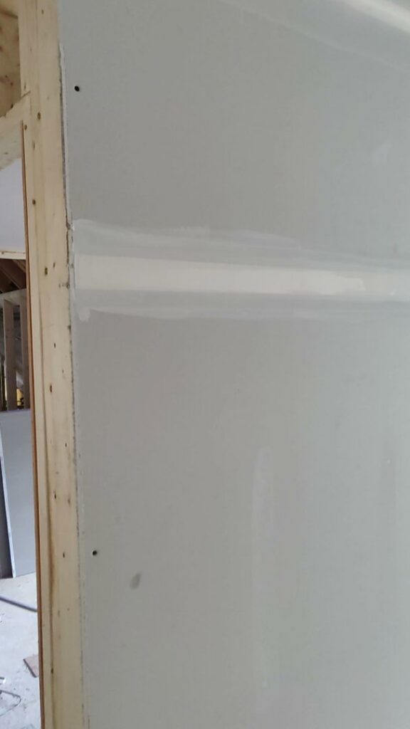 A close-up of a perfectly taped and mudded drywall seam, demonstrating quality finishing by New England Drywall in Springfield, MA.