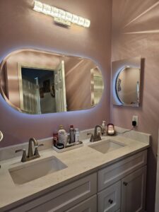 A newly installed dual-sink bathroom vanity with modern mirrors and lighting by Peninsula Bath & Tile in Salisbury, MD.