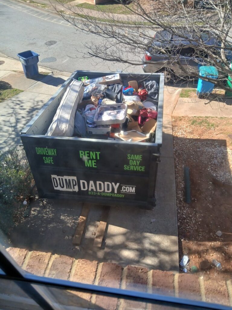 A Dump Daddy dumpster filled with household junk on a residential driveway in Buford, GA.
