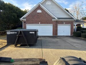 A Dump Daddy junk removal dumpster positioned on a residential driveway in Buford, GA.