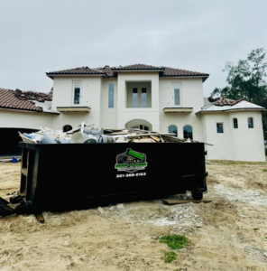 A Dump N Gone dumpster full of renovation debris in front of a large residential house under construction in Apopka, FL.