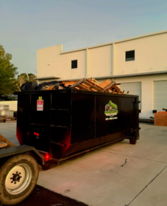 A Dump N Gone dumpster trailer filled with construction debris outside a commercial building in Apopka, FL.