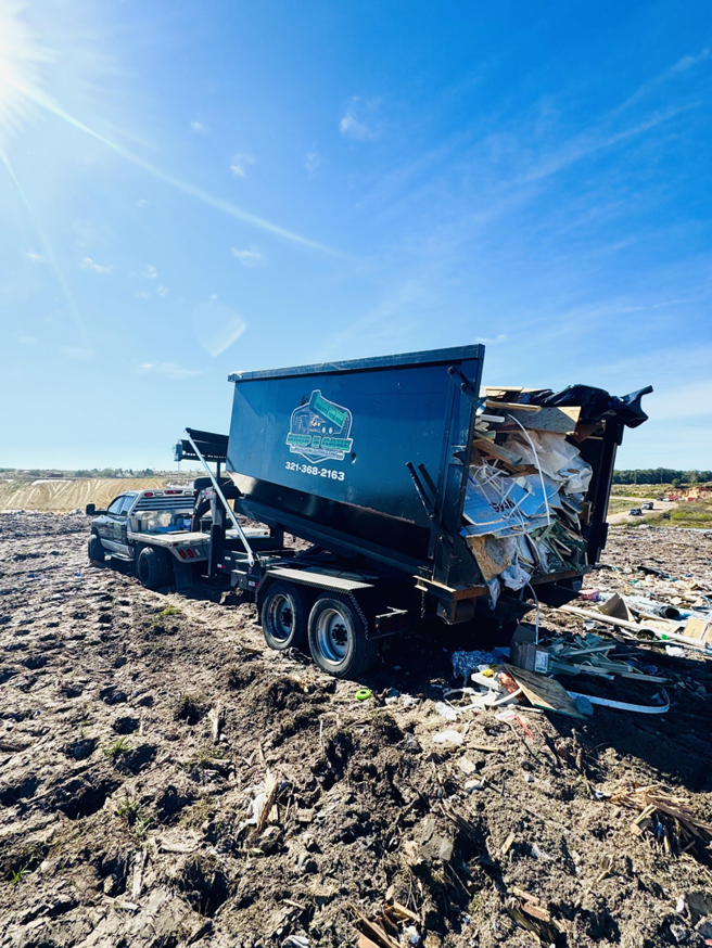 A Dump N Gone truck actively dumping a full load of junk and debris at a disposal site in Apopka, FL.
