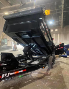 A black dump trailer with its bed raised, demonstrating junk disposal capabilities for S&J Rental and Removal in Ogden, UT.