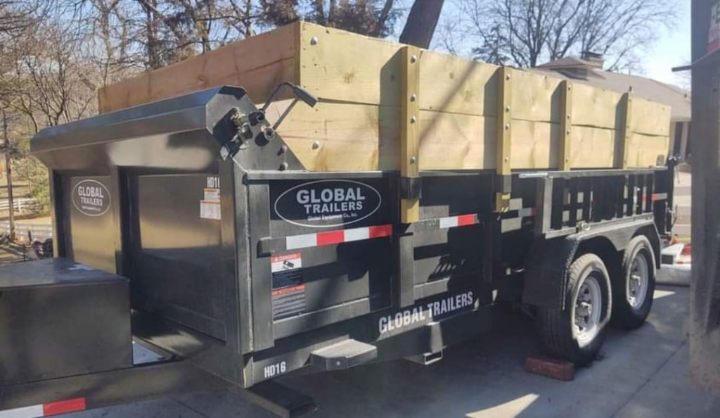 A close-up view of an empty dump trailer with wooden extensions in a residential setting from Big O Dumpster in Omaha, NE.