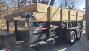 A close-up view of an empty dump trailer with wooden extensions in a residential setting from Big O Dumpster in Omaha, NE.