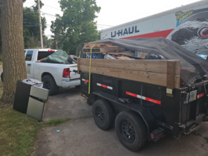 A dump trailer filled with debris and old appliances for removal by The Junkyard Gentlemen LLC in Appleton, WI.