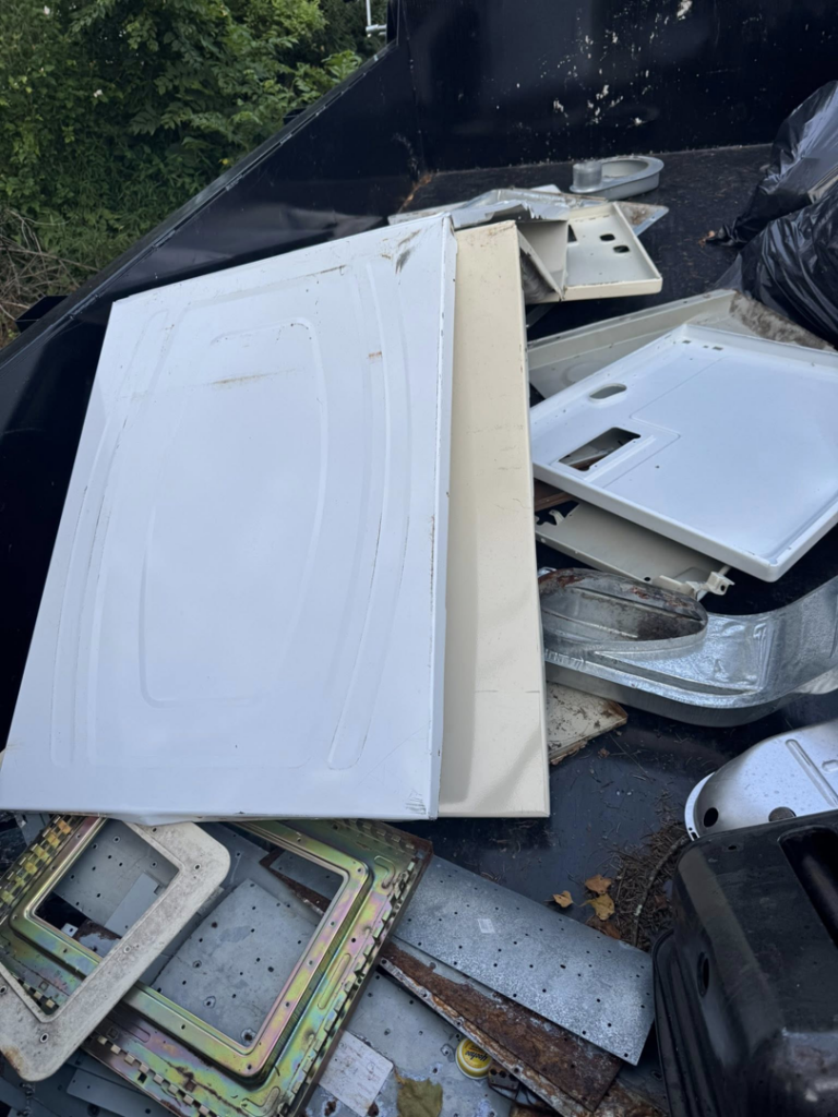 A dump trailer filled with various metal junk and appliance parts, ready for hauling by Nu Earth Hauling and Recycling in Allentown, PA.