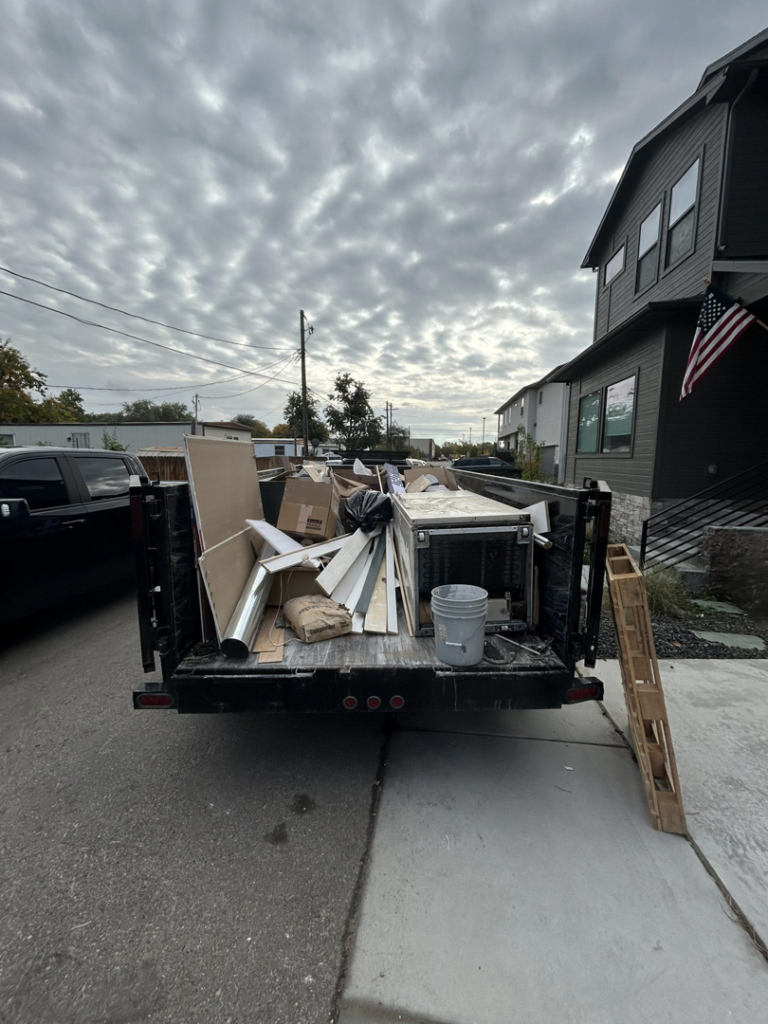 A dump trailer filled with construction debris and junk, ready for removal by Haul My Load LLC in Caldwell, ID.