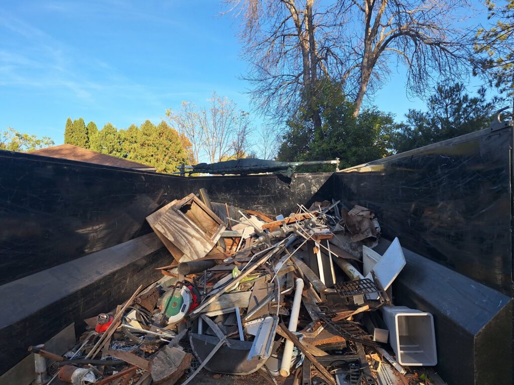 A large dump trailer filled with construction debris and various junk items, demonstrating services by Sunshine junk removal LLC in Lake City, MN.