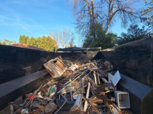 A large dump trailer filled with construction debris and various junk items, demonstrating services by Sunshine junk removal LLC in Lake City, MN.