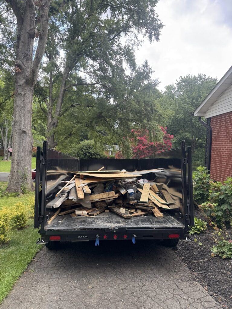A Junkjet dump trailer filled with wood debris and construction waste after a cleanup job in Charlotte, NC.
