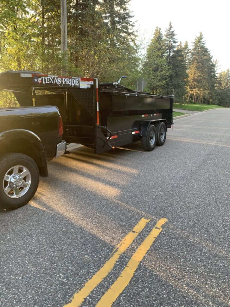 A dump trailer full of yard waste and branches being hauled by Mr. Groundhog Disposal and Services in Bloomington, MN.