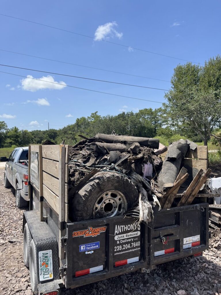 A dump trailer filled with tires, wood, and various debris being hauled by Anthony's Junk Removal & Delivery LLC in Cape Coral, FL.