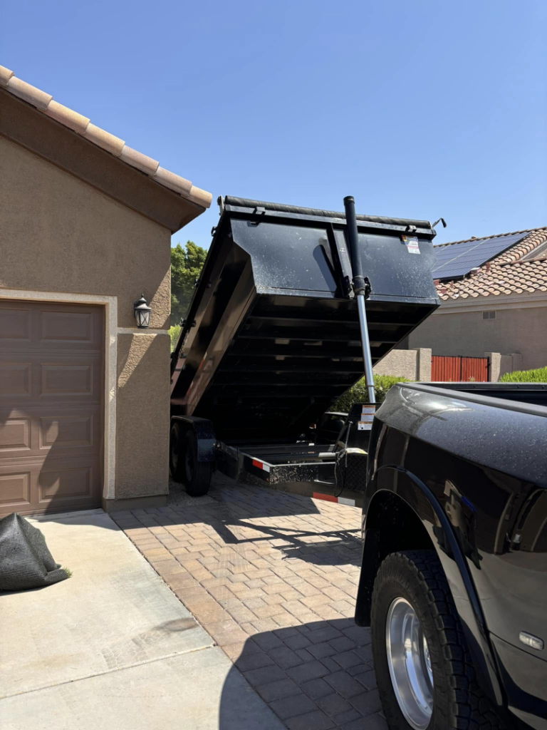 A black dump trailer being raised, ready for a junk removal job by Sunrise Mountain Hauling LLC in Peoria, AZ.