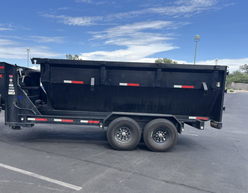 A black dump trailer parked in a lot, ready for junk removal by Royal Environmental Services in Tucson, AZ.