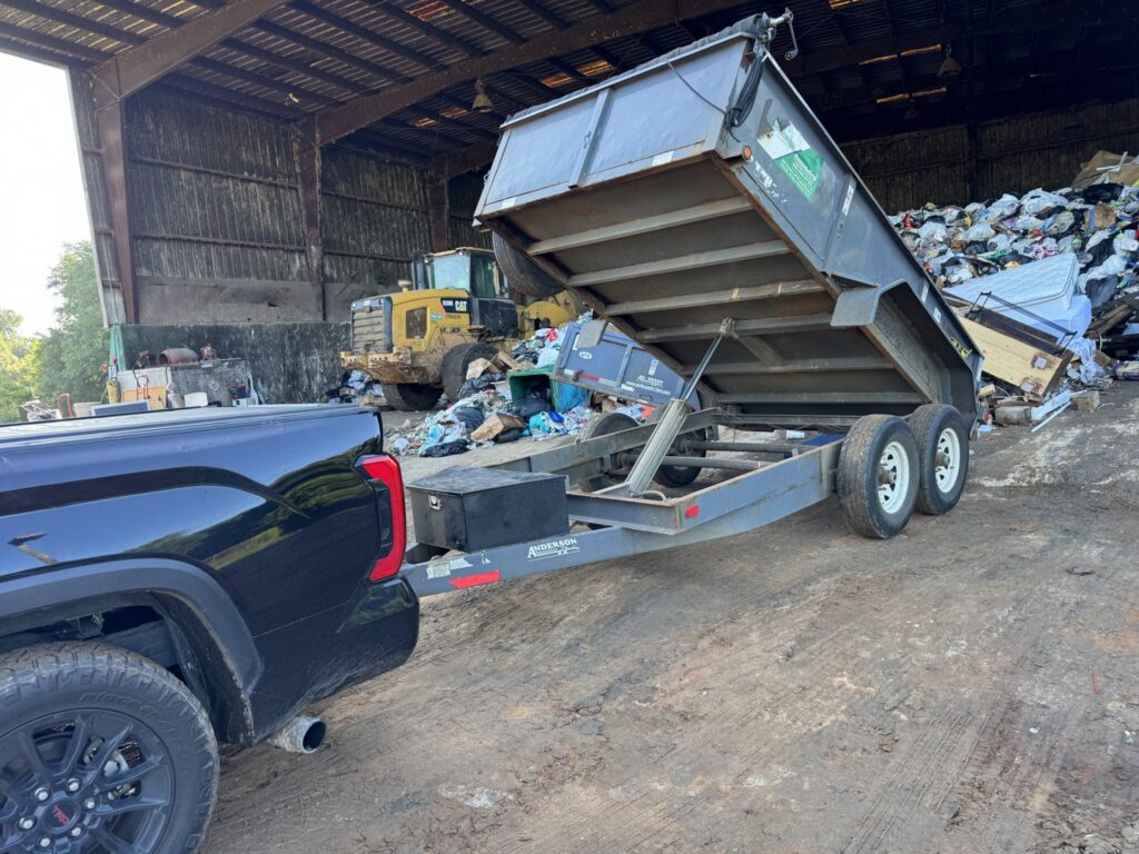 A truck with a dump trailer at a landfill, disposing of collected junk and debris by L.P.Z Trash & Junk Removal in Tallahassee, FL.