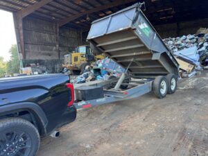 A truck with a dump trailer at a landfill, disposing of collected junk and debris by L.P.Z Trash & Junk Removal in Tallahassee, FL.