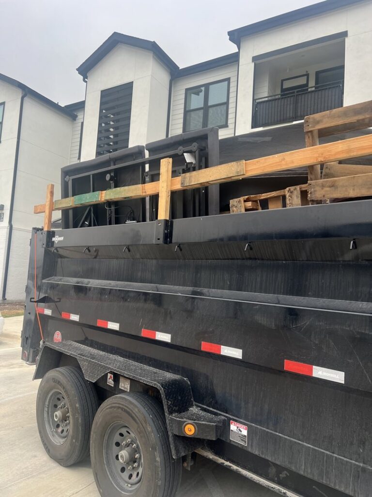 A dump trailer loaded with wooden pallets and construction debris, handled by Silverhull Junk Removal in San Antonio, TX