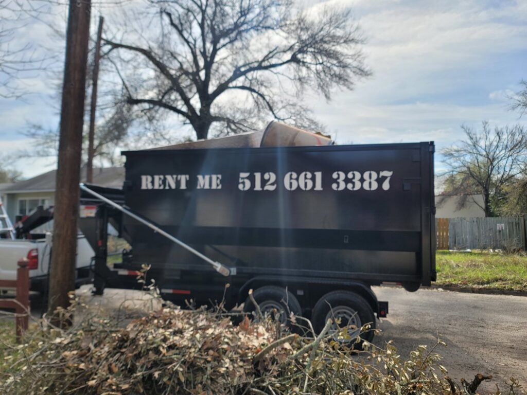 A dump trailer from Team512 filled with branches and debris, performing waste removal in Austin, TX