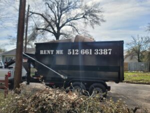 A dump trailer from Team512 filled with branches and debris, performing waste removal in Austin, TX
