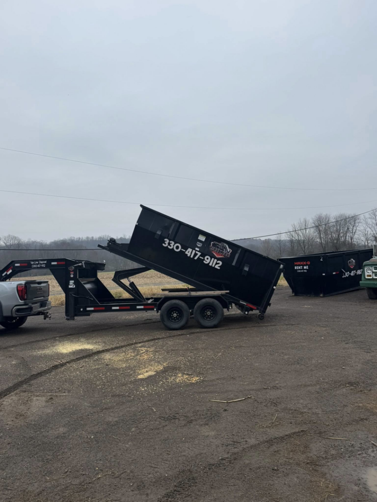A Van Line Disposal, LLC dump trailer tilting to load or unload junk during a general junk removal job in East Canton, OH.