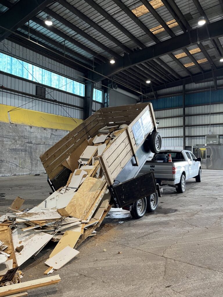A dump trailer unloading construction debris at a disposal site for Anthony's Junk Removal & Delivery LLC in Cape Coral, FL.