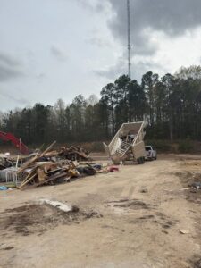 A Dumpzilla dump trailer unloading a large pile of construction and general debris at a disposal site in Raleigh, NC.