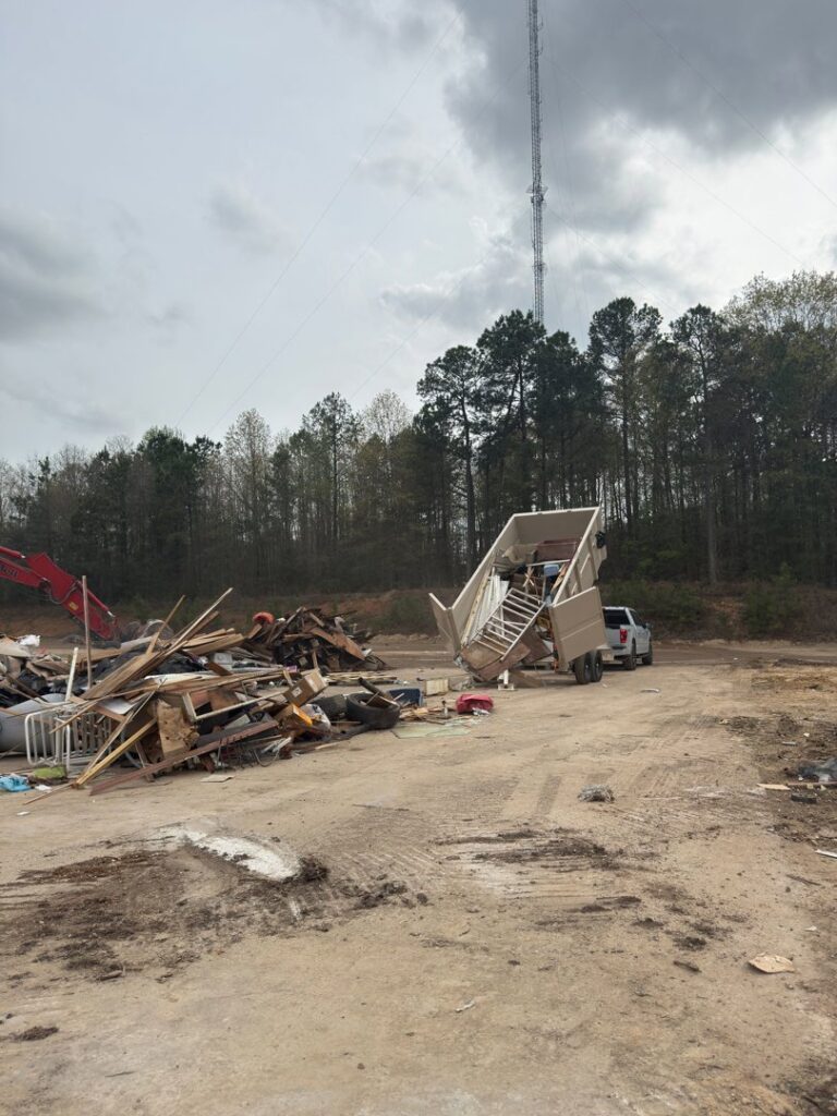 A Dumpzilla dump trailer unloading a large pile of construction and general debris at a disposal site in Raleigh, NC.