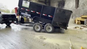 A dump trailer from D's Dumpster Rentals unloading debris inside a building in Overland Park, KS.