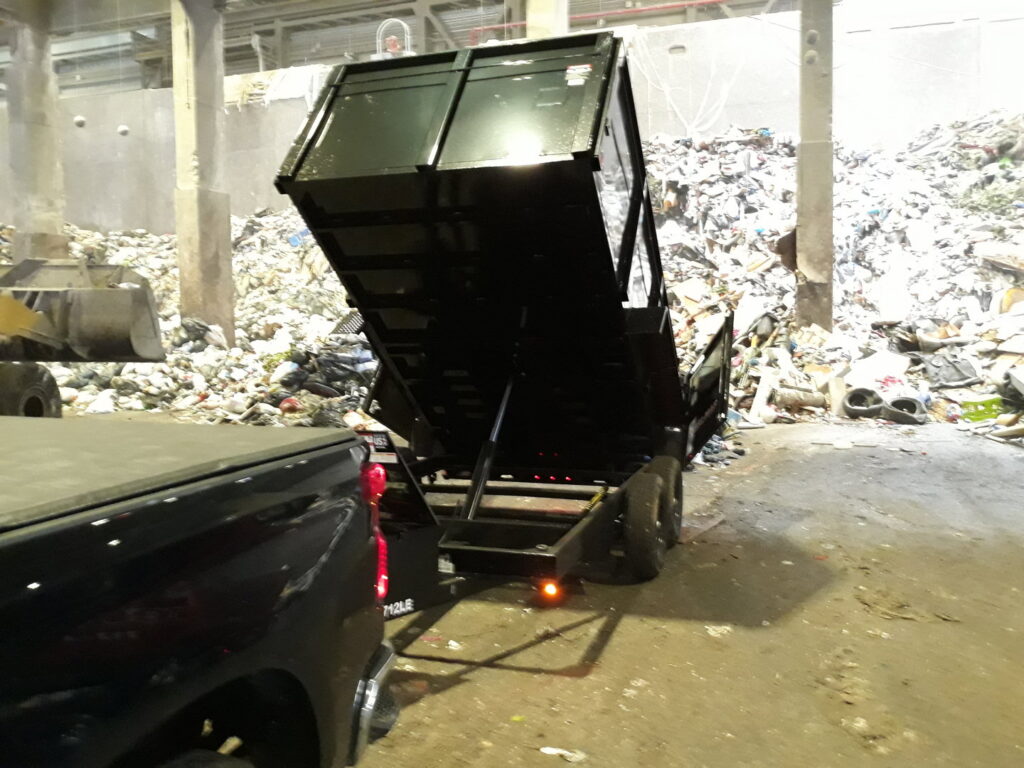A Removall Residential and Commercial Cleanout Services dump trailer unloading collected junk at a waste facility in York, PA.
