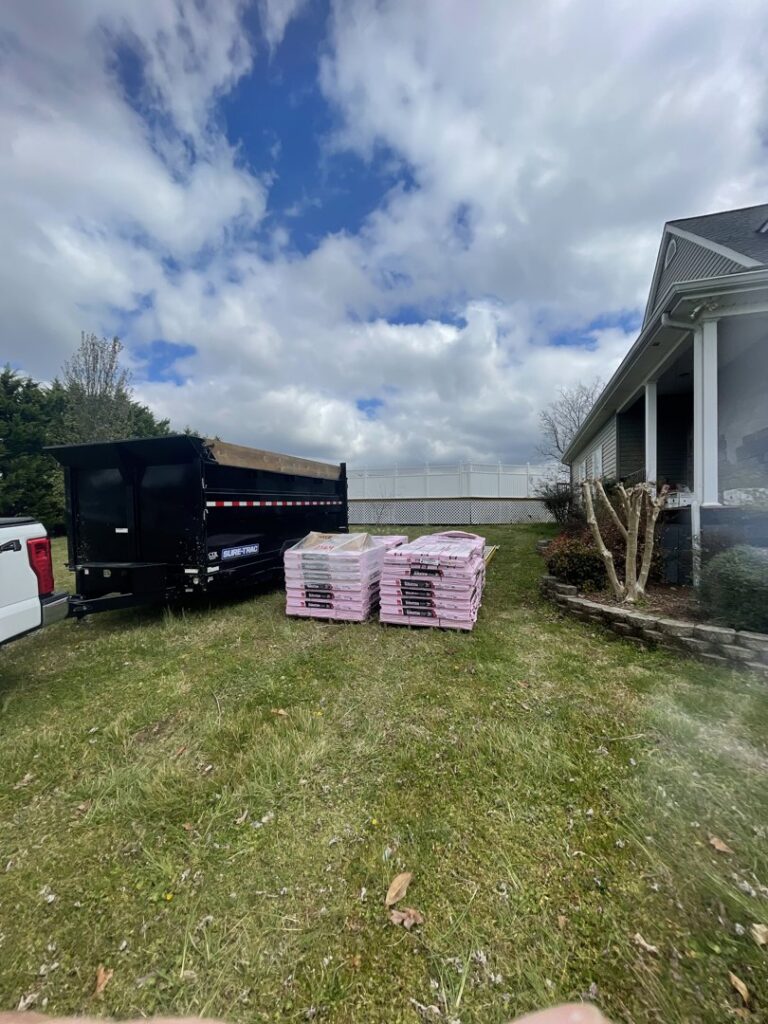 A dump trailer from Mobile Dumpster Solutions parked with building materials at a residential site in Chattanooga, TN.
