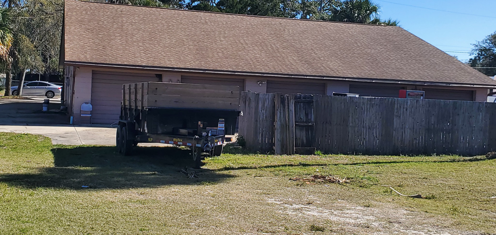 A dump trailer from BigDumpster.com parked in a grassy area with small debris piles in Cleveland, OH.