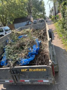 A dump trailer filled with yard waste and branches, ready for removal by WeHaul Hauling & Junk Removal in Sioux Falls, SD.