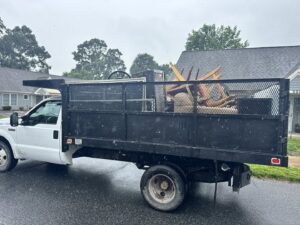 A dump truck loaded with various junk items for disposal by Insta Junk Removal & Demolition LLC in Salisbury, MD