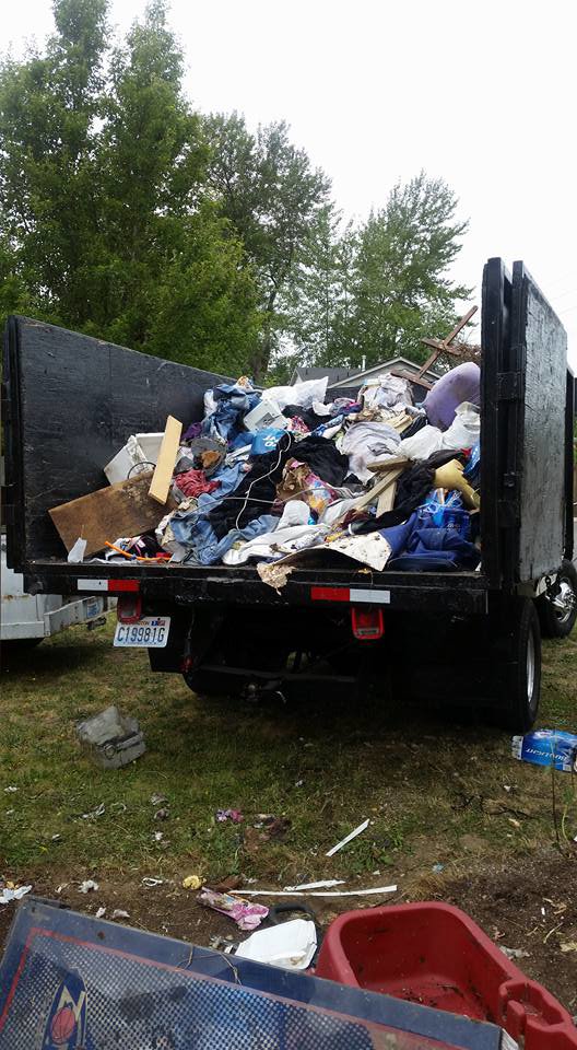 A large dump truck overflowing with a diverse load of household junk and trash, collected by Down and Dirty Junk Removal in Tacoma, WA.