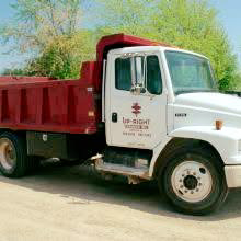 A white dump truck used for snow removal and trenching by Upright Services Inc in Green Bay, WI.