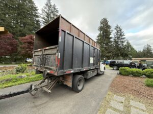 A dump truck with an attached trailer, used by AA Tree Service for hauling equipment and debris in Kent, WA.