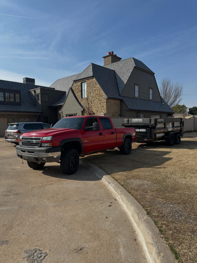 Ricky's Dump Truck with a dump trailer parked at a residential property in Oklahoma City, OK, ready for junk removal.