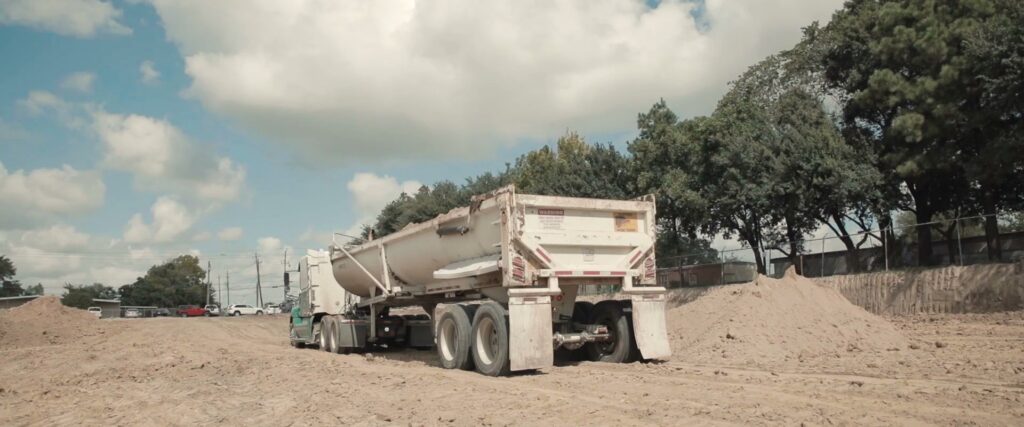 A dump truck transporting materials on a construction site, part of a project by Sendero Industries in Houston, TX.