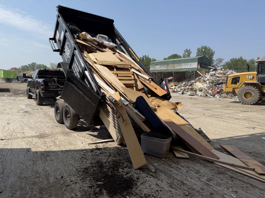 A dumpster trailer unloading construction debris at a disposal site for Anywhere Dumpster Rental in Bolingbrook Area, IL.