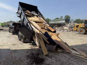 A dumpster trailer unloading construction debris at a disposal site for Anywhere Dumpster Rental in Bolingbrook Area, IL.