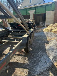 A dumpster on a trailer being used at a residential construction site by HD Waste Services in Chattanooga, TN.