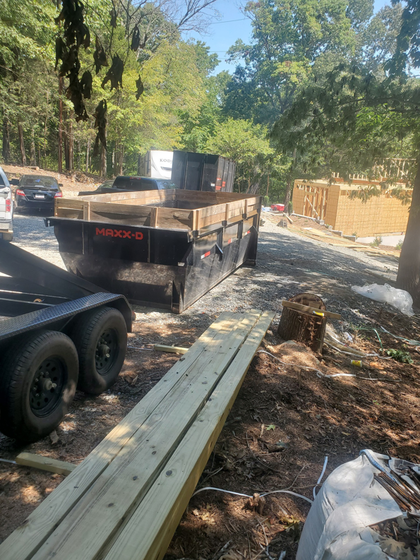 A black dumpster trailer parked at a construction site, ready for debris removal by Standard Dumpster LLC in Rock Hill, SC.
