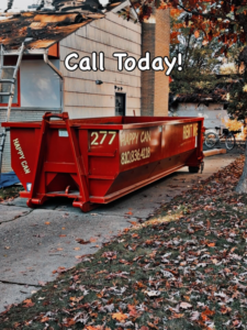 A red Happy Can Disposal dumpster on a driveway at a home renovation site in Flint, MI, ready for junk removal.